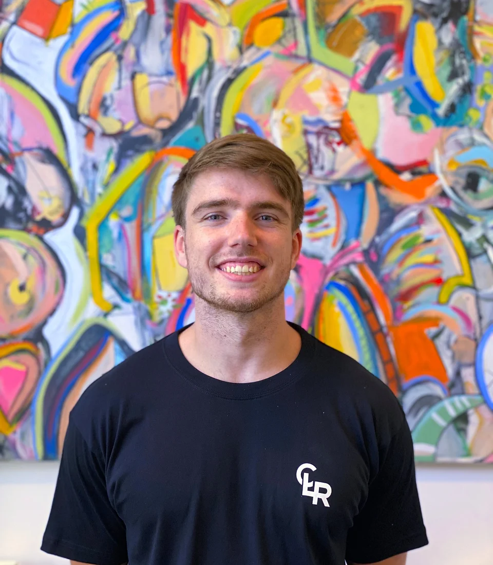 Picture of young male personal Trainer smiling wearing company shirt whats says CLR